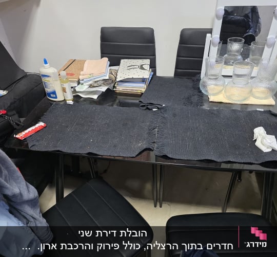 שולחן עם חפצים שונים, כולל בקבוקים ומראה